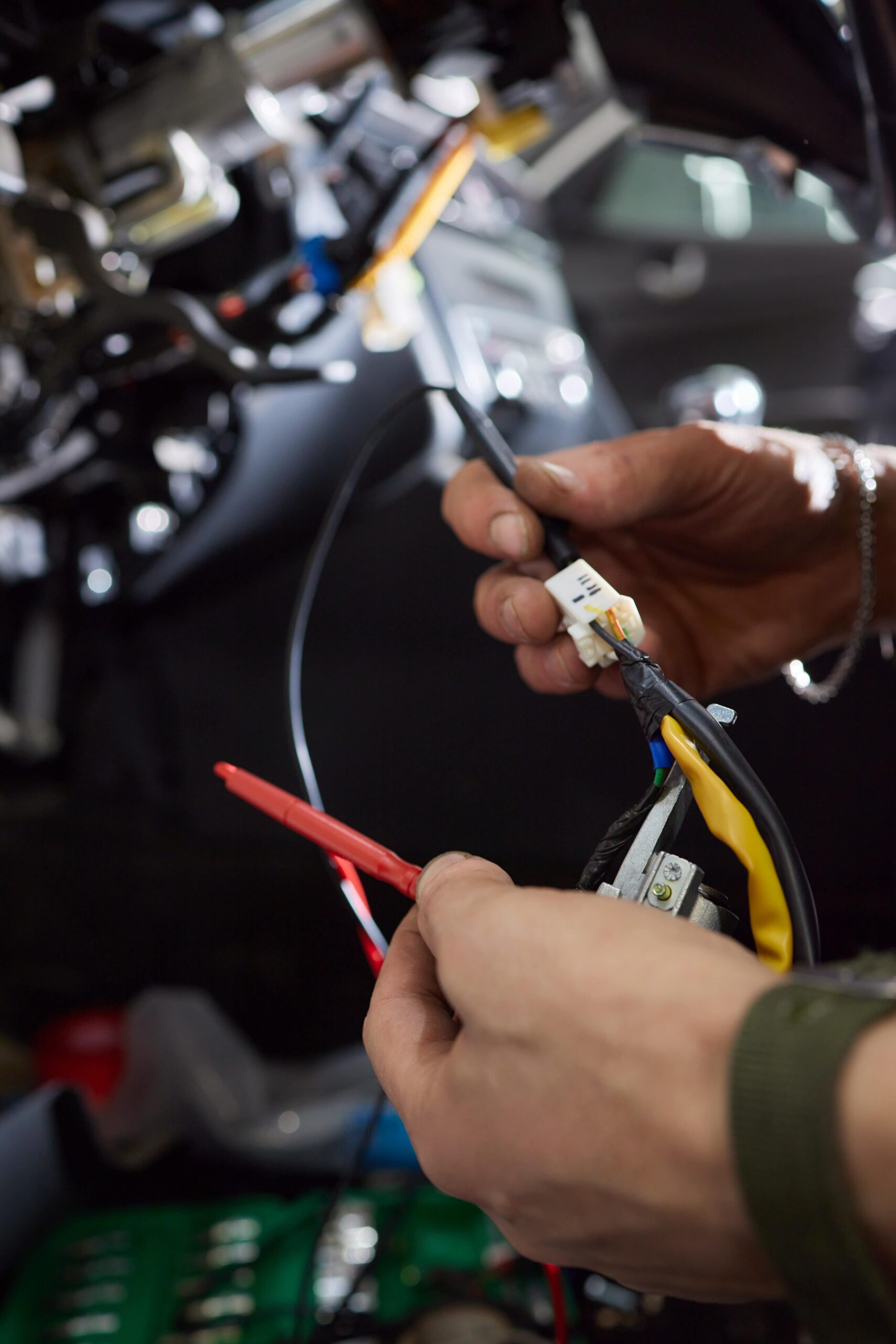 Auto electrician worker is installing a car alarm